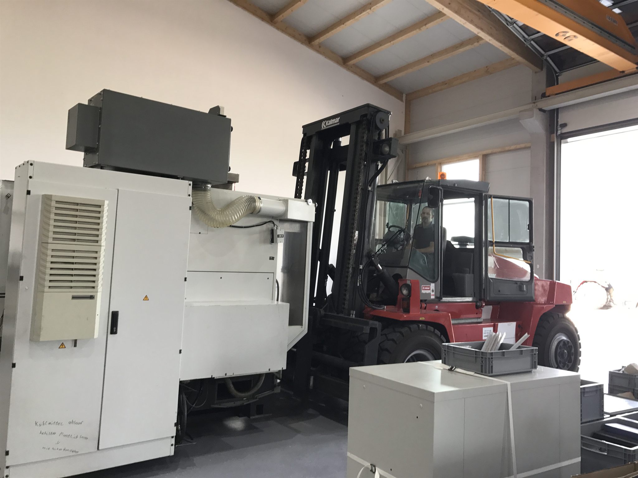 In der neuen Halle: eine Anlage wird auf ihren Platz gesetzt, oben die Kranbahn