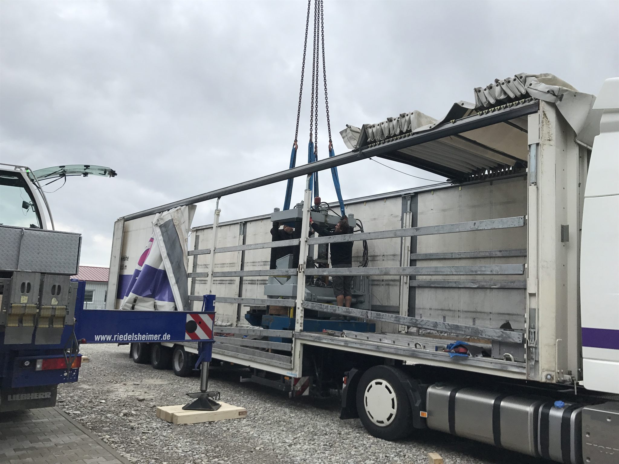 11. August: eine Maschine wird am Kran auf einen Sattelzug verladen