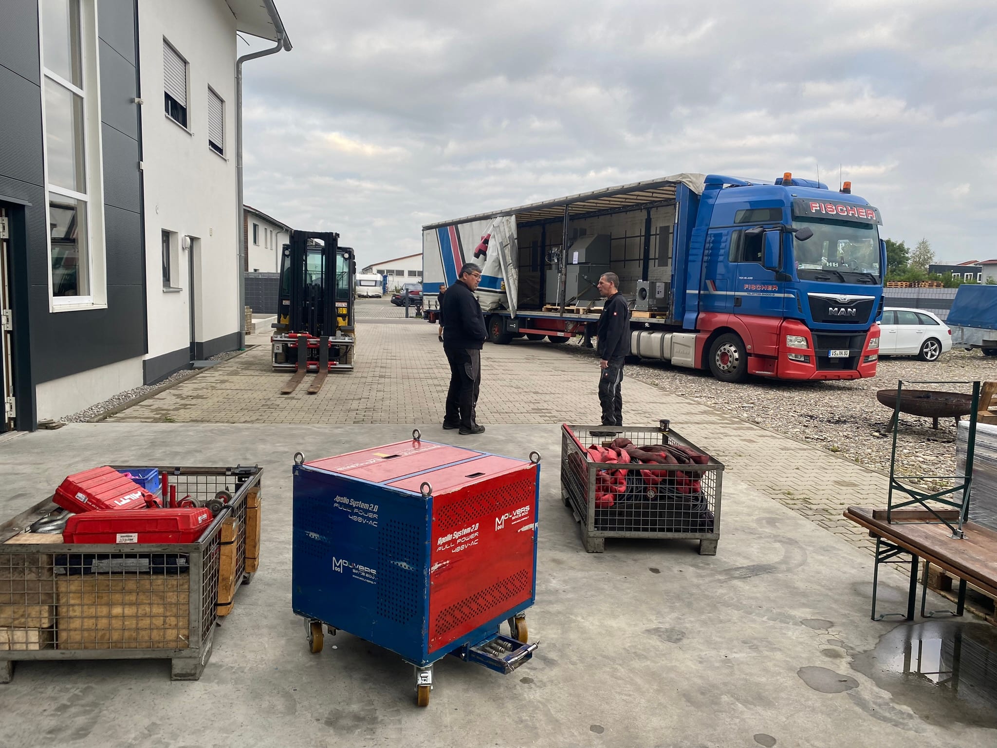 Der Sattelzug mit der C650U steht am Morgen vor der Halle, im Vordergrund Gitterboxen mit Anschlagmitteln