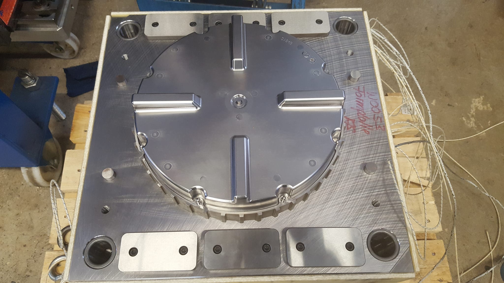 Runde Werkzeughälfte für Duroplast auf einer Palette, in der Mitte die Kavität mit Auswerferleisten, am Rand die angeschlossenen Thermoelemente