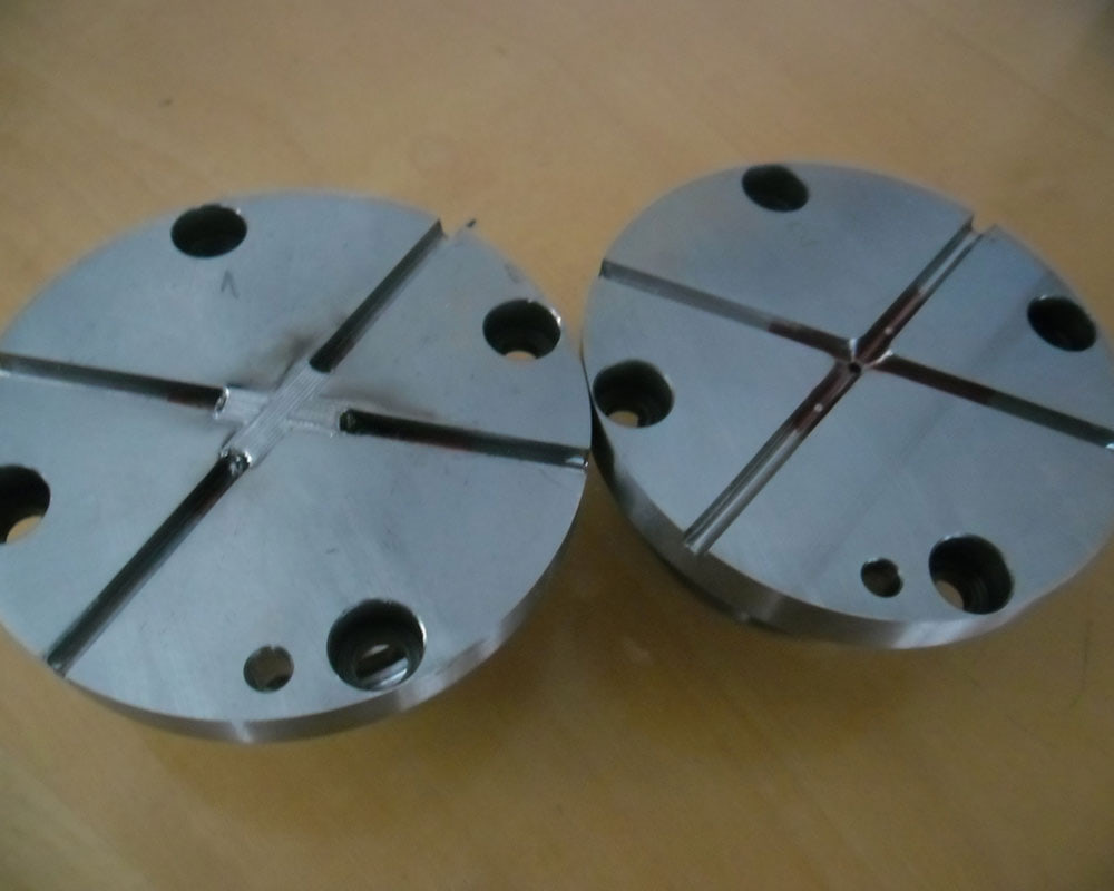 Zwei runde Platten mit Kreuznut, an einer der Kreuzungspunkt aufgetragen