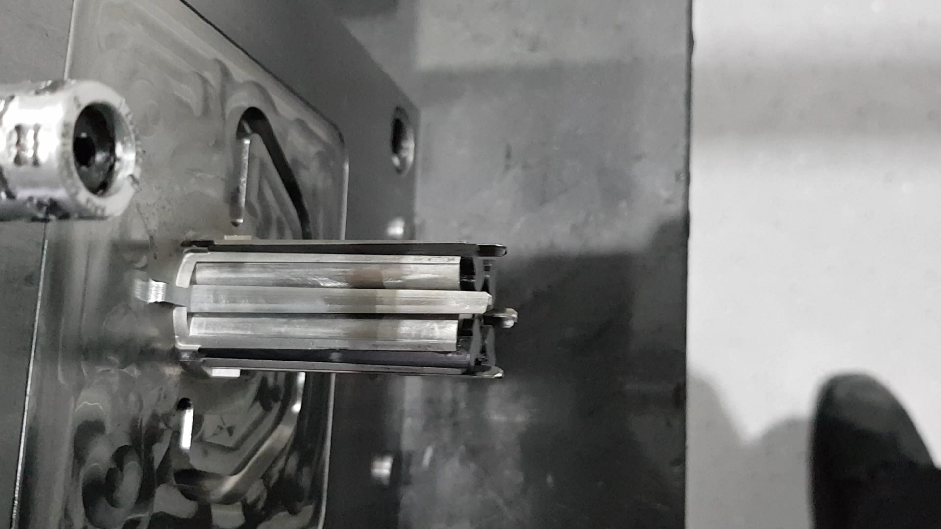 Nahaufnahme einer Werkzeughälfte: zwischen den gefrästen Flächen steht ein Schieber mit blank geschliffenen Laufflächen vor